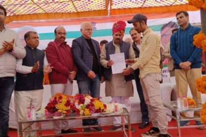 शिविर में लाभार्थी को कार्ड सौंपते अतिथि।