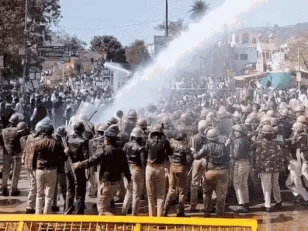 प्रदर्शन करते कार्यकर्ताओं को वॉटर कैनन से रोकती पुलिस।